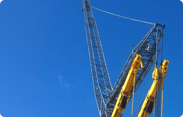 Yellow cranes against a clear blue sky.