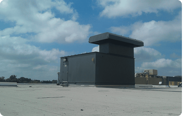 Rooftop view with ventilation system and clouds.